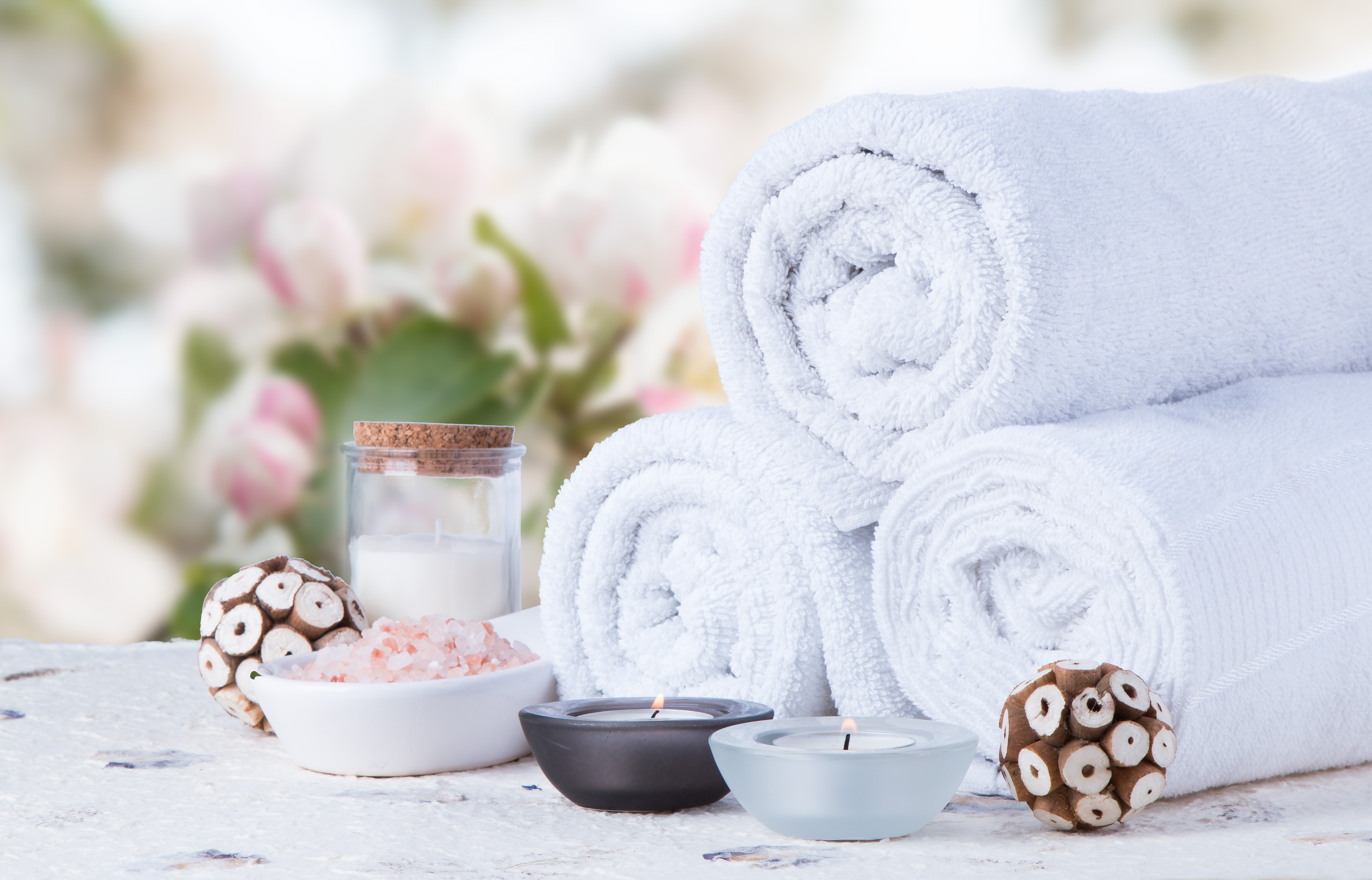 spa massage setting, product, oil on white table with flower background